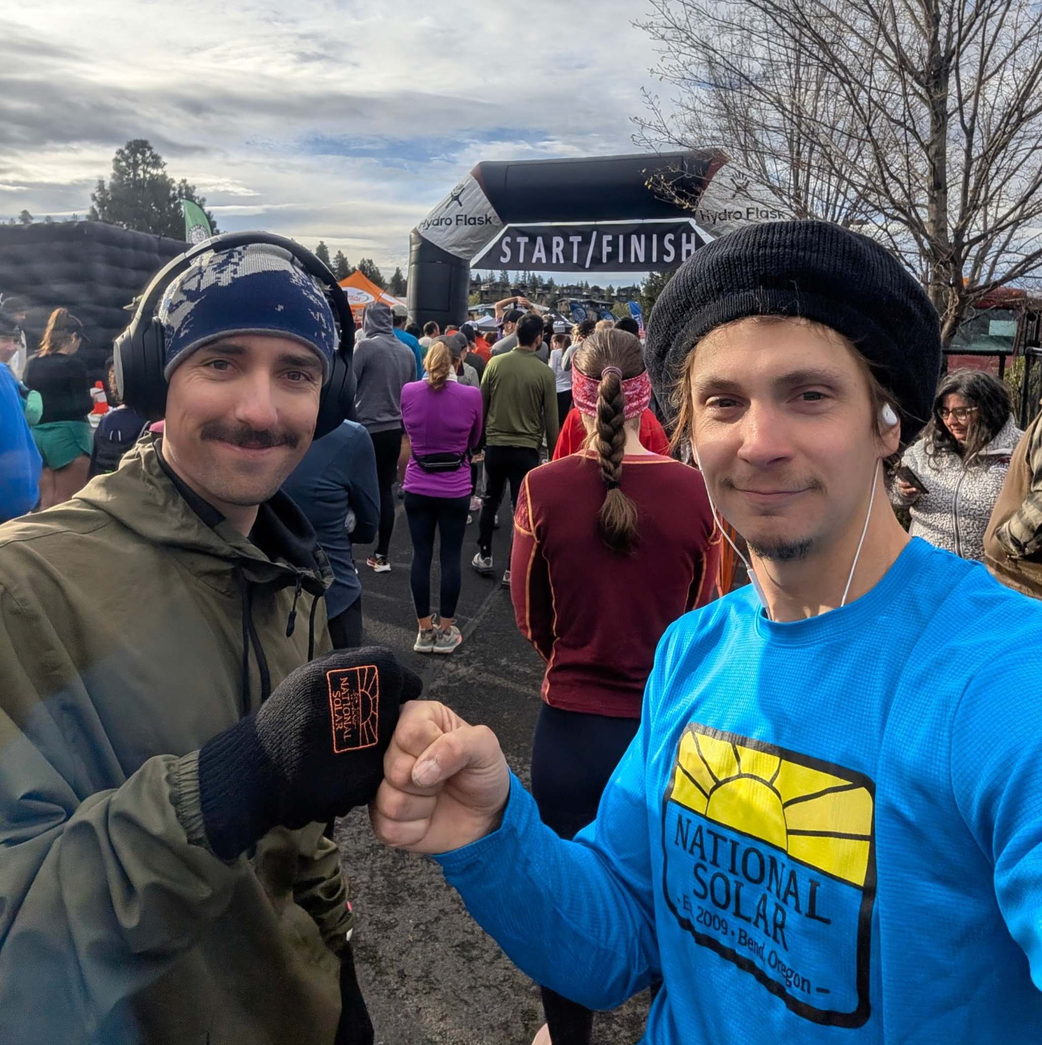 Two National Solar teammates take a photo together at the Bend Marathon start and finish area.