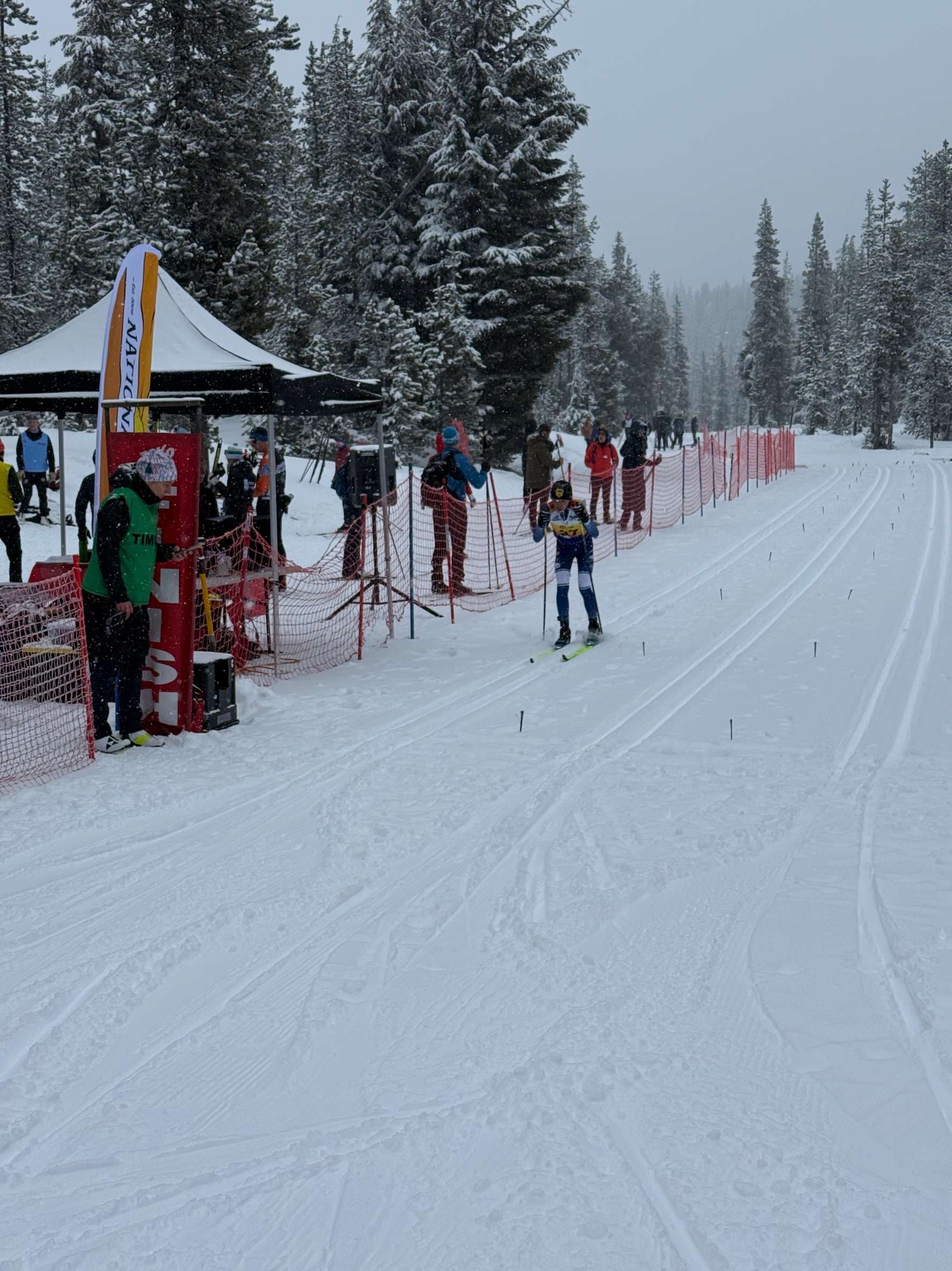 A young cross-country skier racing on a snowy trail through Mt. Bachelor’s forest.