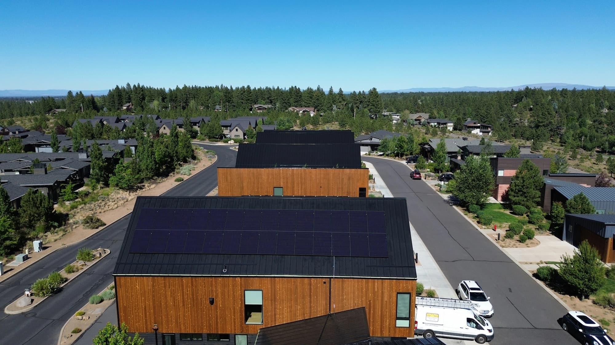 Aerial view of a modern Oregon home with a fully paneled solar roof.